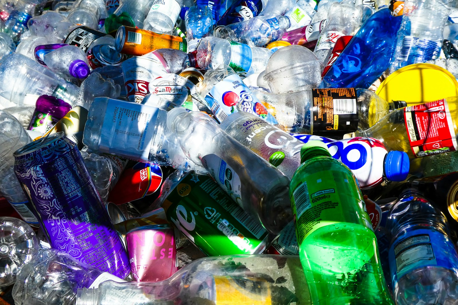 Pile of discarded plastic bottles and cans including brands common in the Philippines
